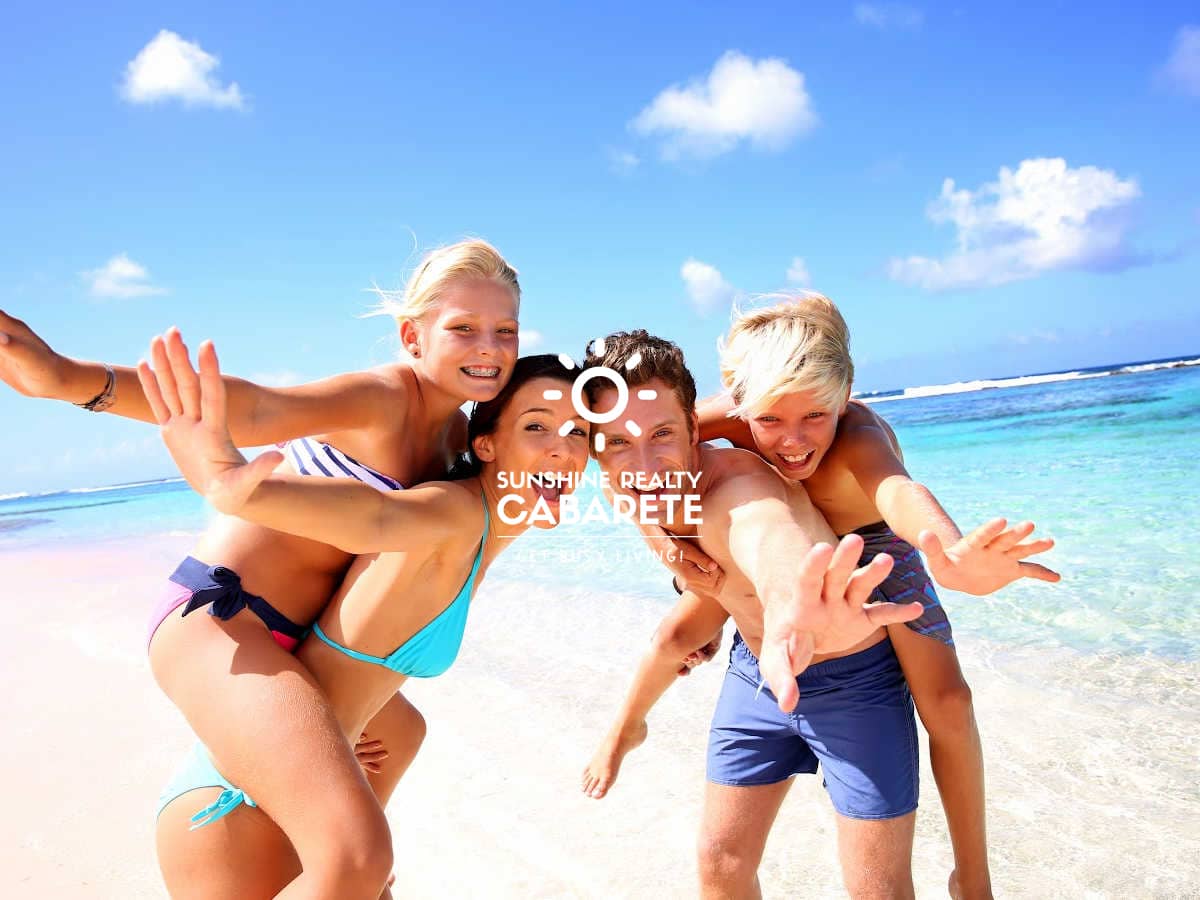 Image of a husband and wife and two kids playing on the beach in Cabarete, Dominican Republic